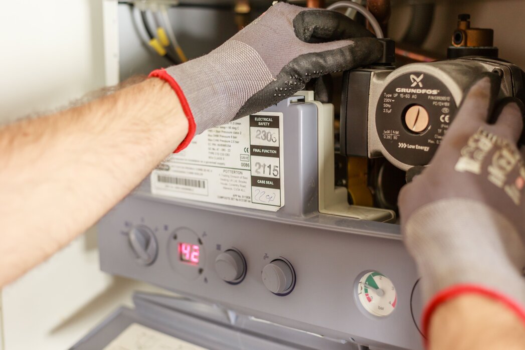 Servicetechniker prüft Außeneinheit einer Wärmepumpe